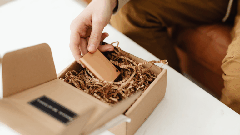 Kuvassa paketoidaan pientä powerbank-laturia tyylikkääseen pakettiin